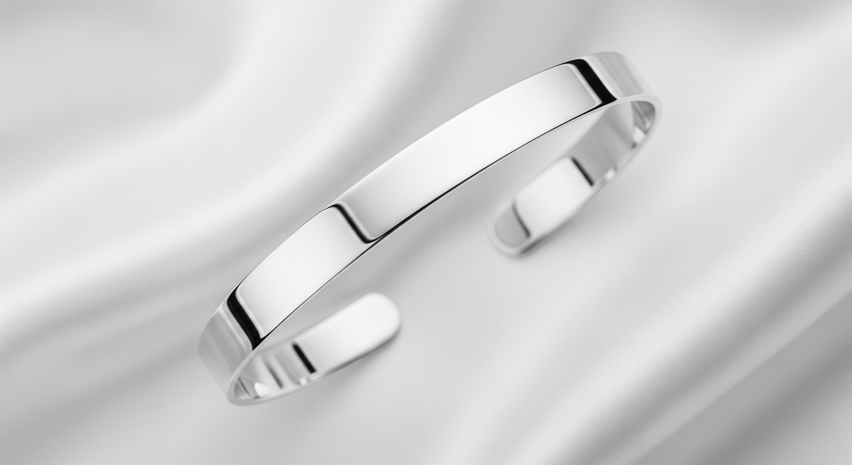 Reflective silver bracelet on a white cloth background
