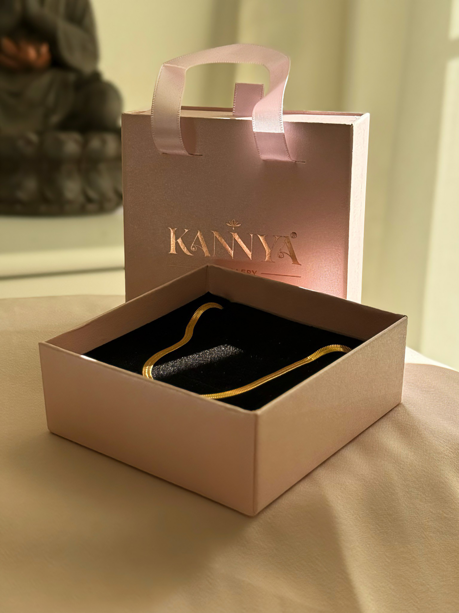 Kannya branded box with a Kannya gold chain inside on a neutral background